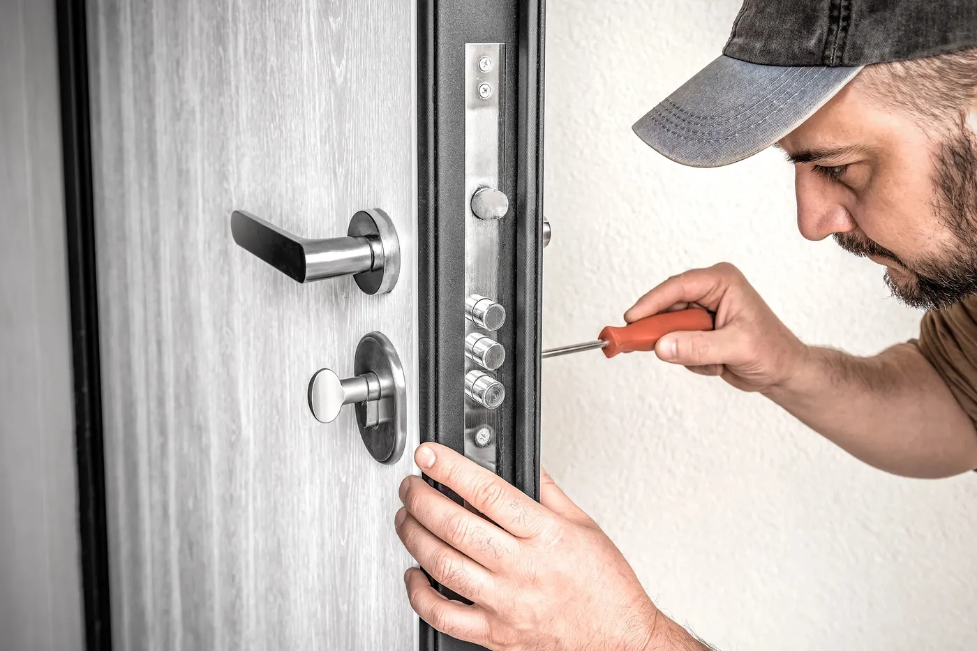 Artisan serrurier ajustant un cylindre sur une porte d'entrée à Croissy-sur-Seine (78290)